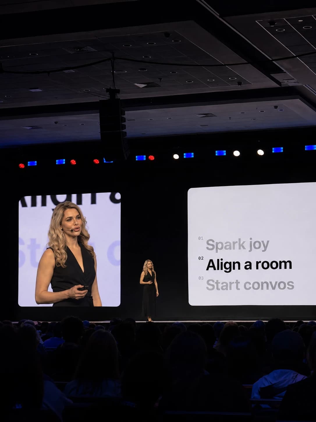 Iryna on a large stage facing an audience, her talk shown on two big screens
